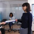 Two professionals reviewing hiring documents in a modern office
