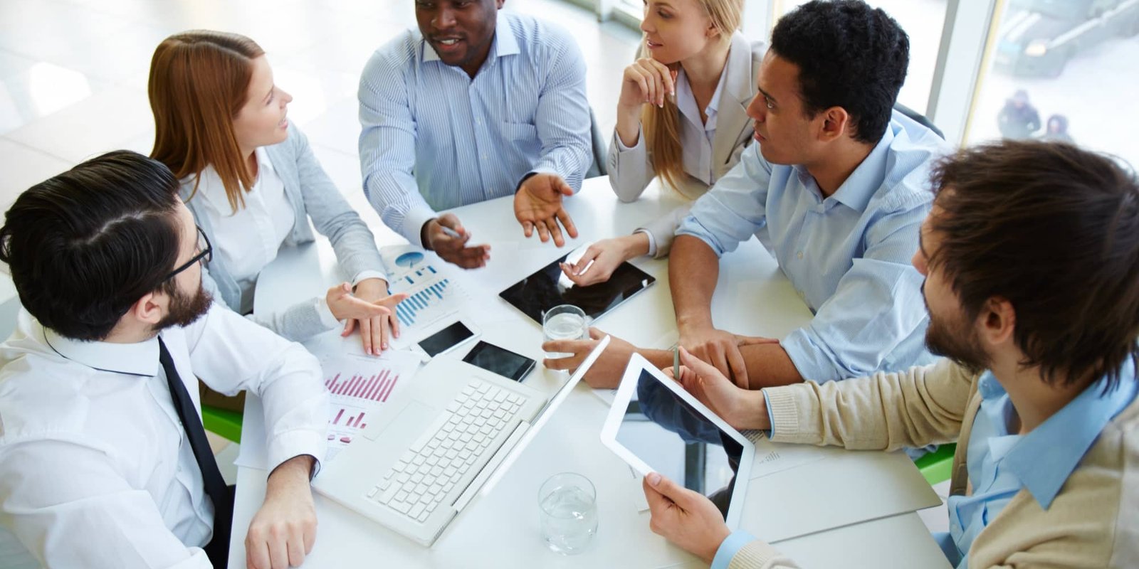 Mixed-gender team collaborating around a table in a bright office