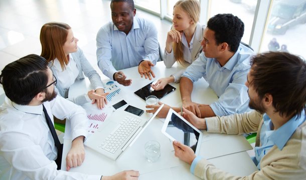 Mixed-gender team collaborating around a table in a bright office