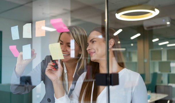 Two professionals mapping employer brand ideas on a glass wall